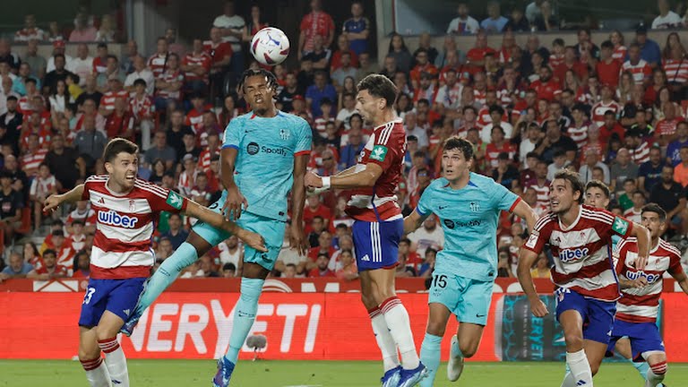 Pemain Granada dan Barcelona saling berebut bola di udara. Kedua tim bermain imbang 2-2.foto:Reuters