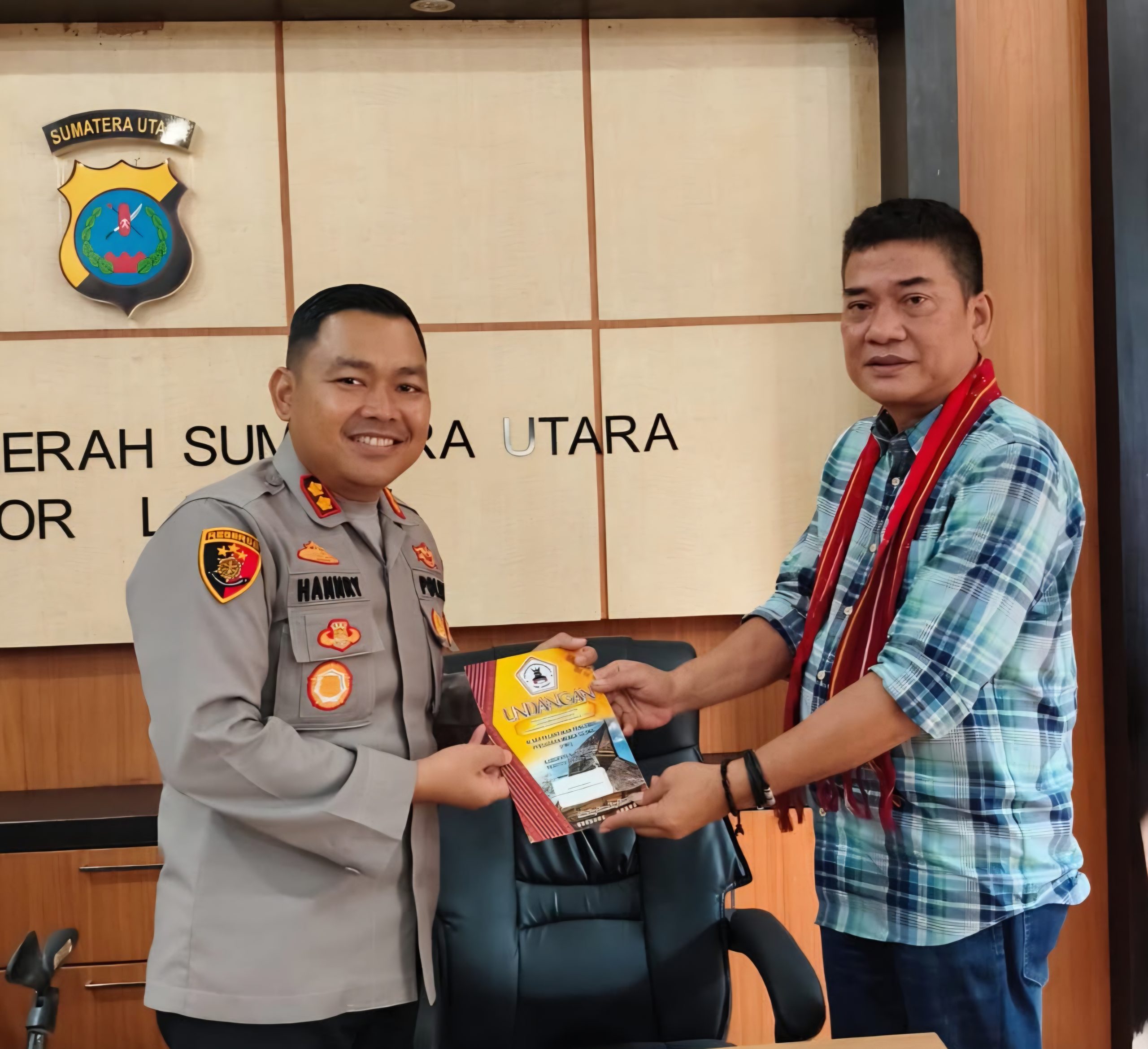 Ketua PMS Langkat Edi Bahagia Sinuraya memberkkan undangan kepada Kapolres Langkat Kapolres Langkat AKBP Hanny P.H. Tambunan. Foto; IST