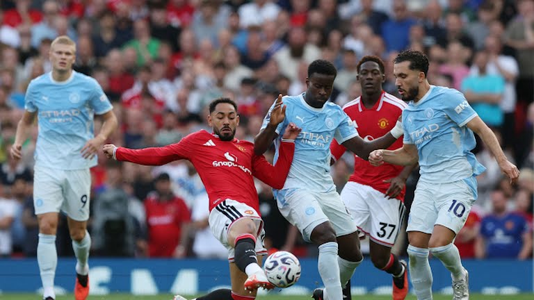Pemain MU berusaha menghadang laju pemain Manchester City dalam lanjutan Liga Inggris di Stadion Old Trafford, Minggu (13/9/2026). Dalam laga itu Manchester City menang lewat gol tunggal Haaland menit 60. Foto: Reuters